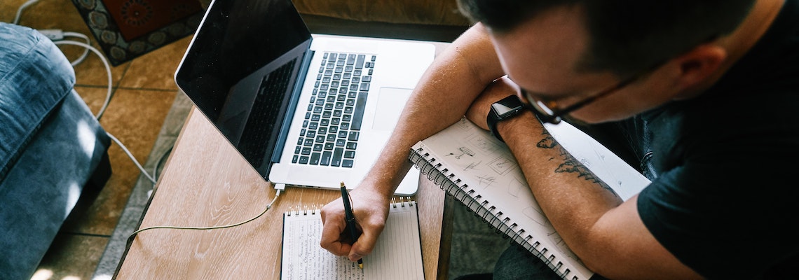 Mid-career technical writer reviewing notes and typing